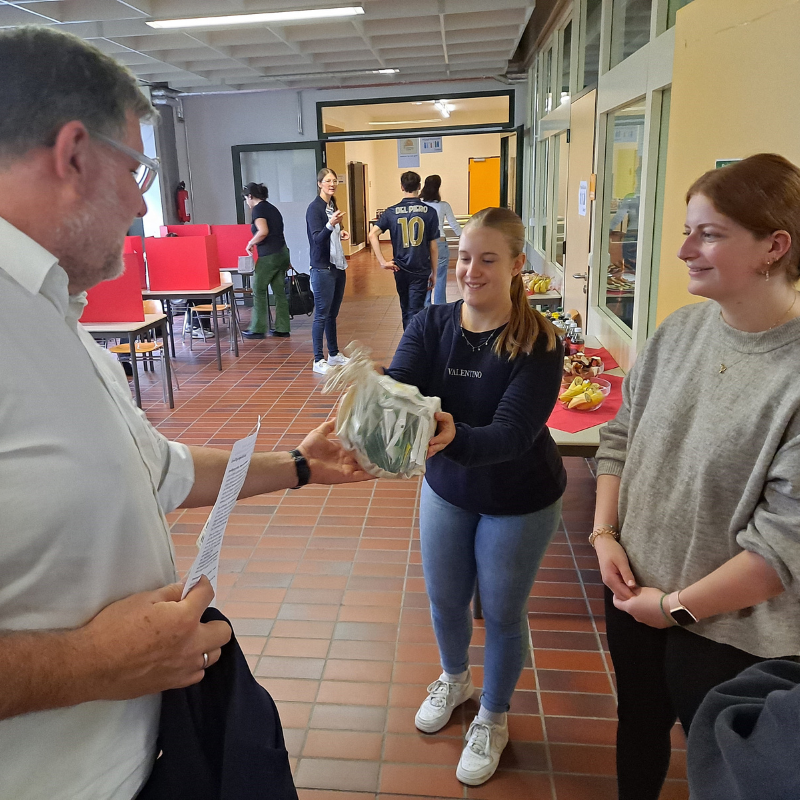 Landrat Fiedler überreicht zwei Schülerinnen der Klasse 1BK1P einen Dankesgruß