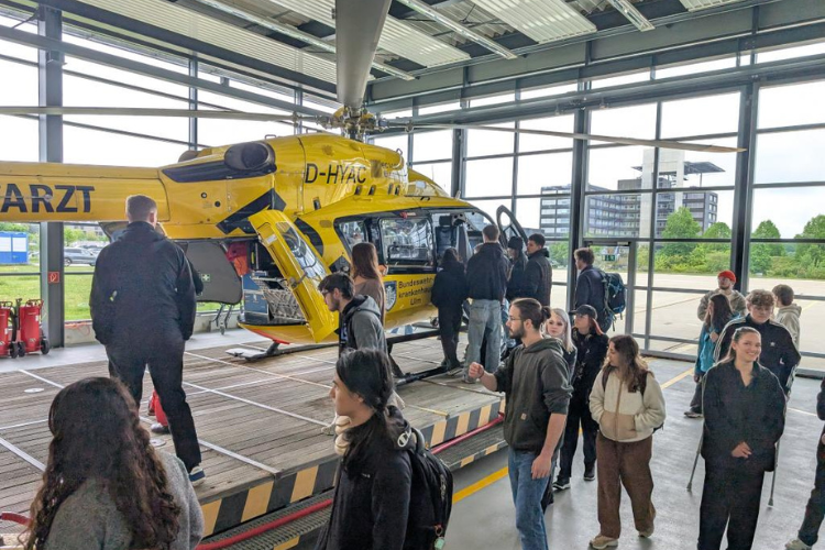 Schülerinnen und Schüler beim Besuch des Bundeswehrkrankenhauses Ulm vor einem Notfallhubschrauber