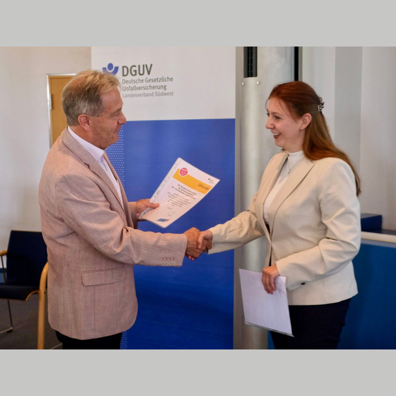 Schülerin der Laura-Schradin-Schule bekommt den ersten Preis für den Kreativwettbewert der DGUV überreicht, an dem der Schulsanitätsdienst teilgenommen hat. 