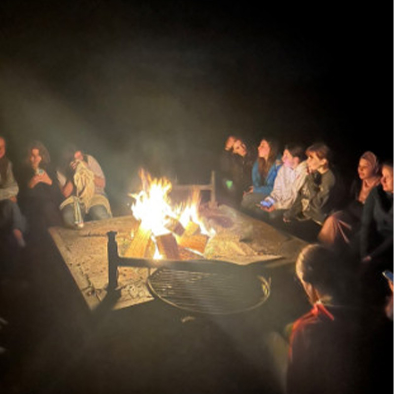 Schülerinnen und Schüler am Lagerfeuer bei der Kennenlernfahrt